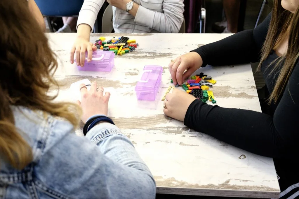 Three participants making Lego constructions.