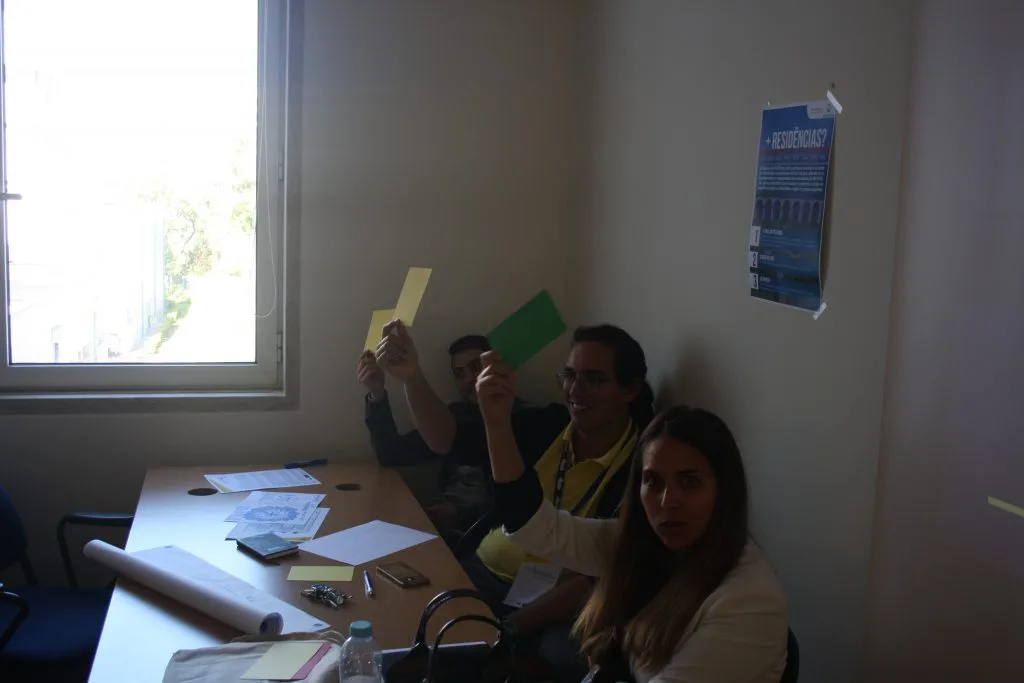 Participants and representatives holding out yellow and green cards, three people.