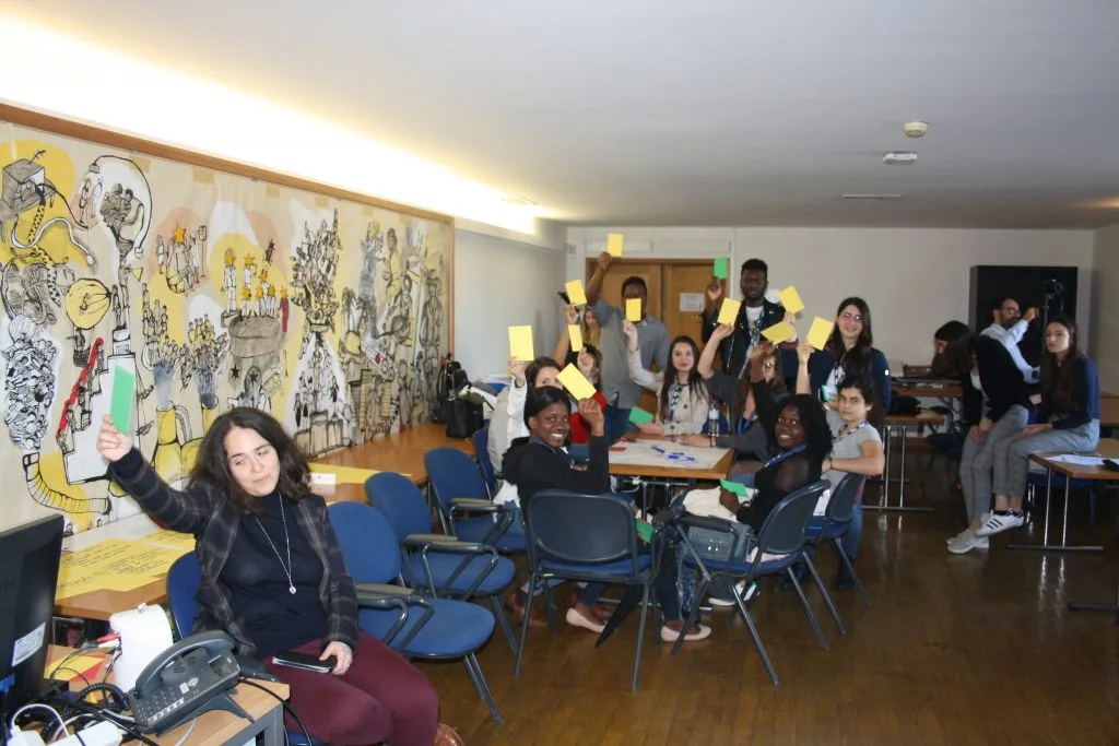 Participants and representatives holding out yellow and green cards.