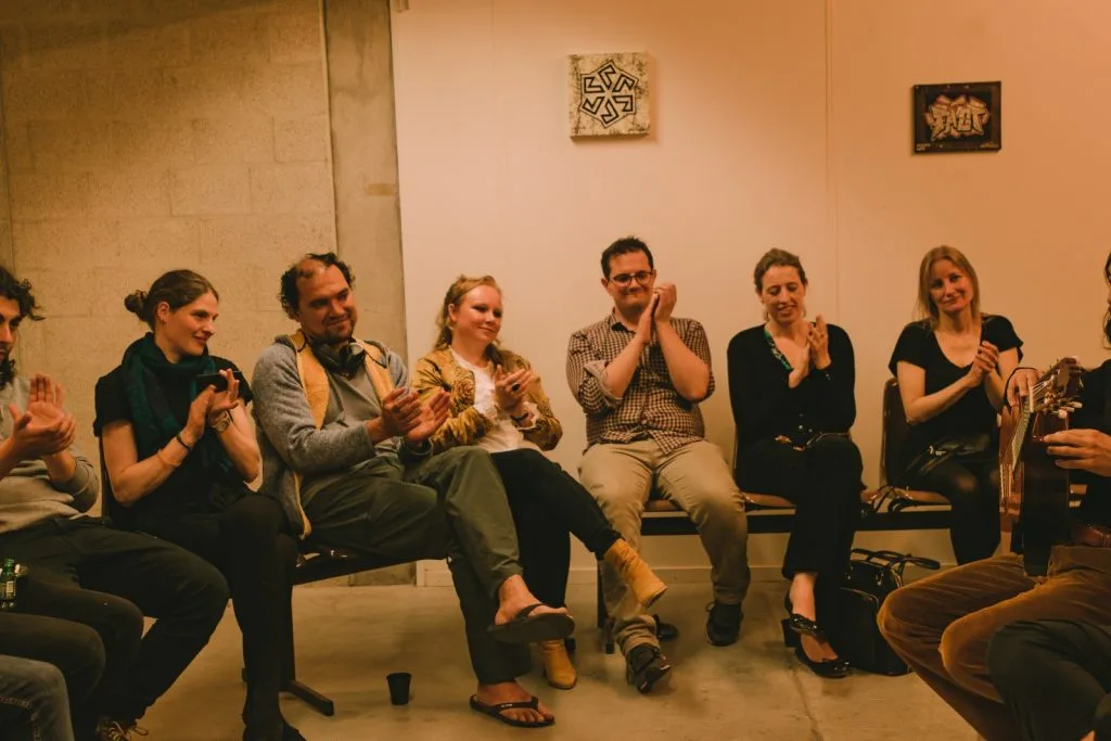 Audience applauding the concert, seven members and one musician.