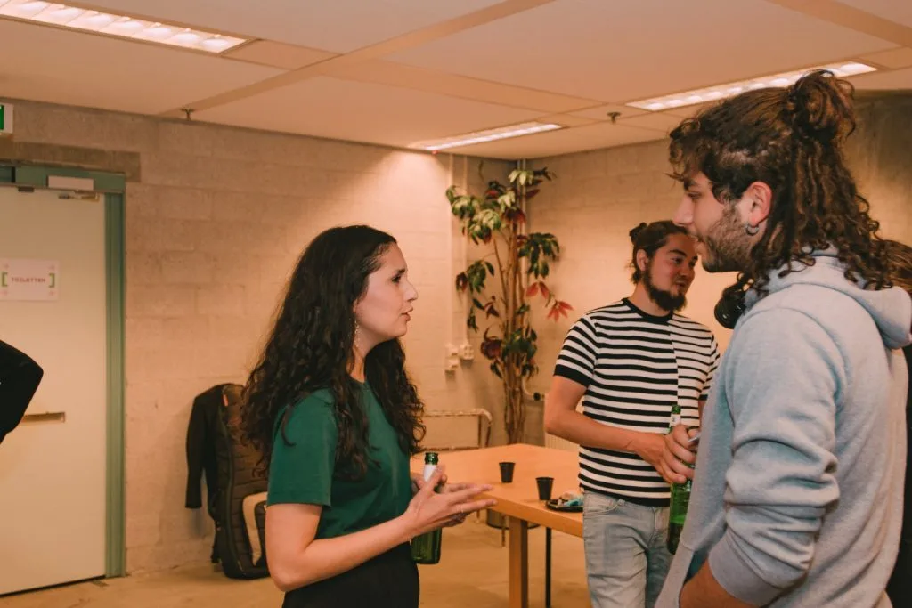 Participants and musician chatting, three people.