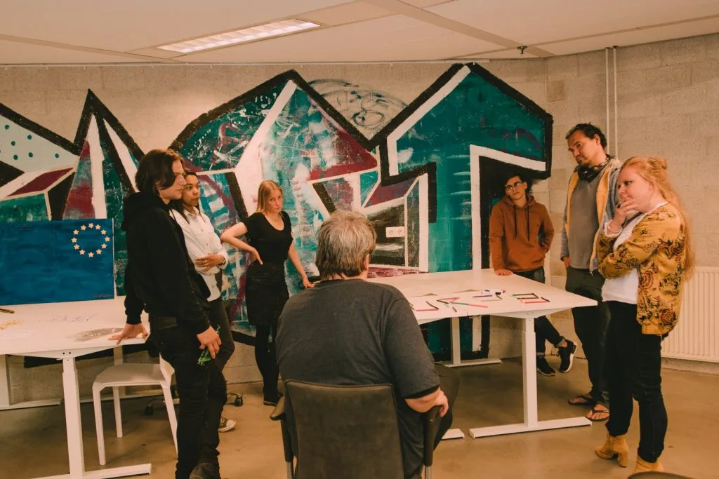Seven people around a table with arts and crafts materials.