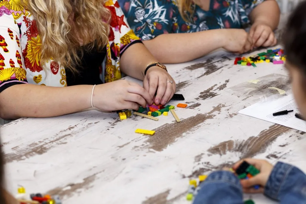 Three participants making Lego constructions.