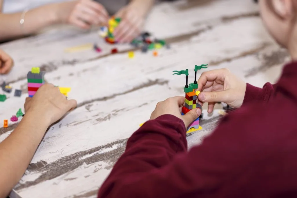 Three participants engaged in Lego construction.