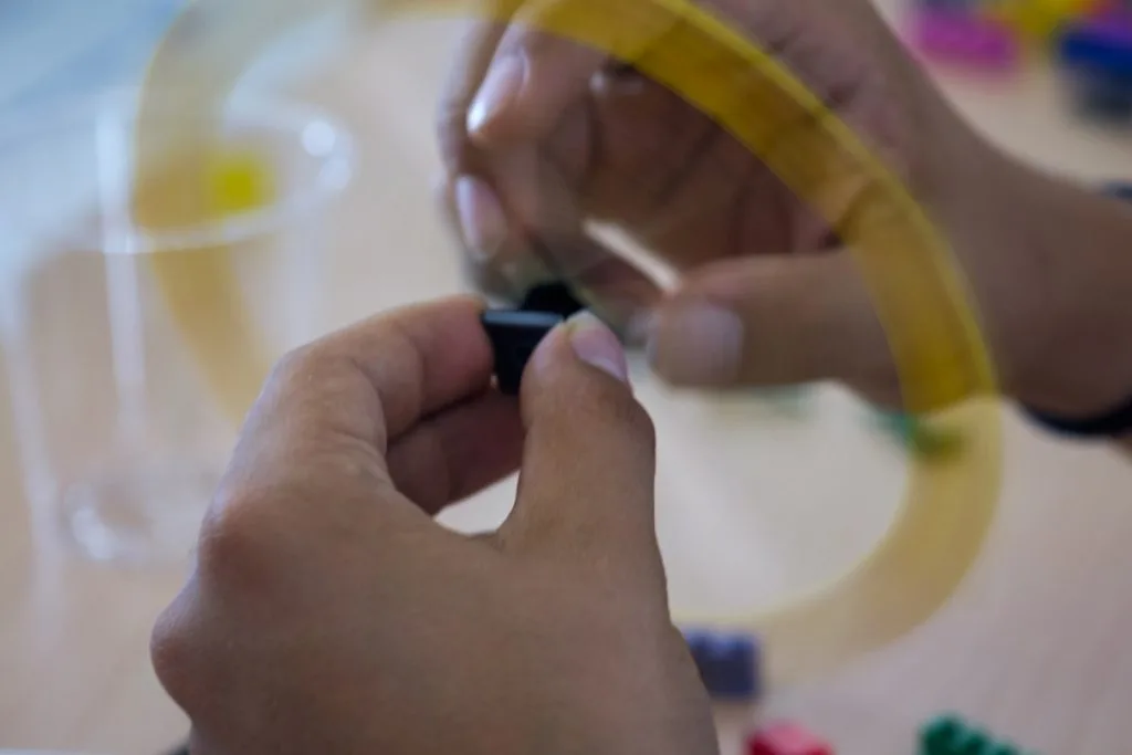 Hands toying with pieces.