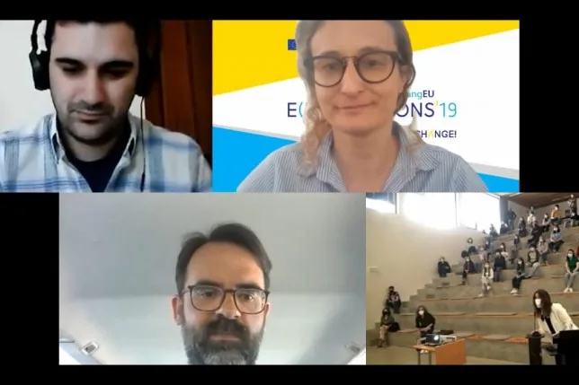 Videoconference still showing the images of the participating partners' representatives and the auditorium of students on the call.