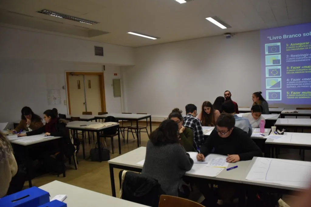 Participants seated in groups working on their posters.