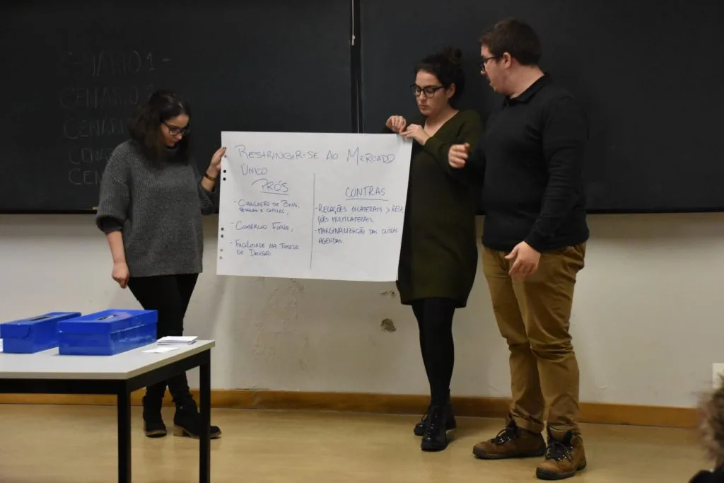 Three students presenting their handwritten poster.
