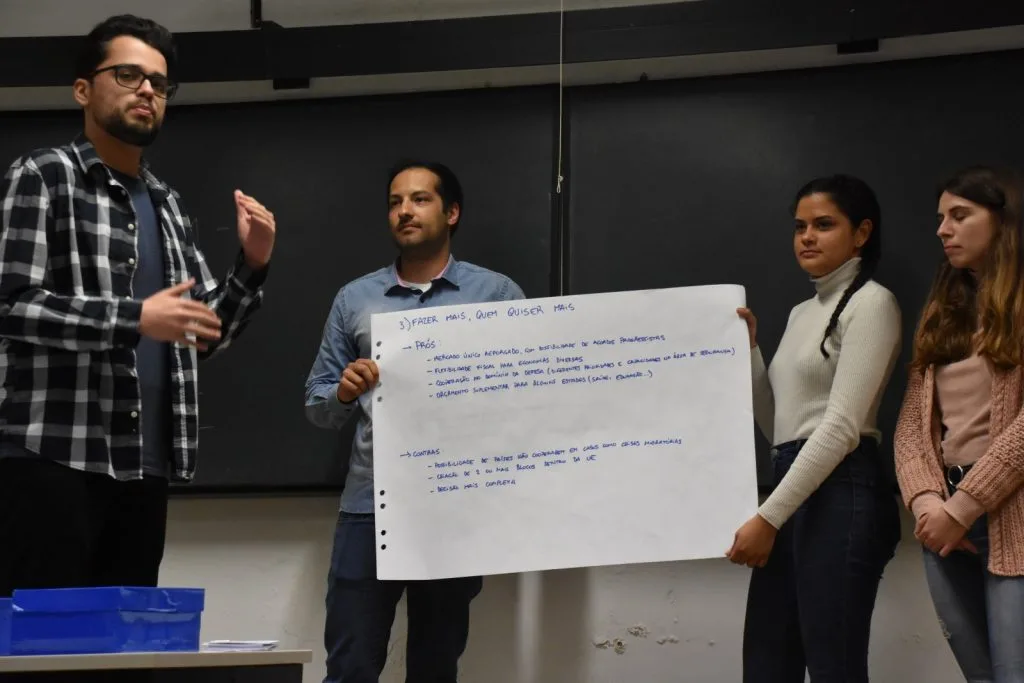Four students presenting their handwritten poster.