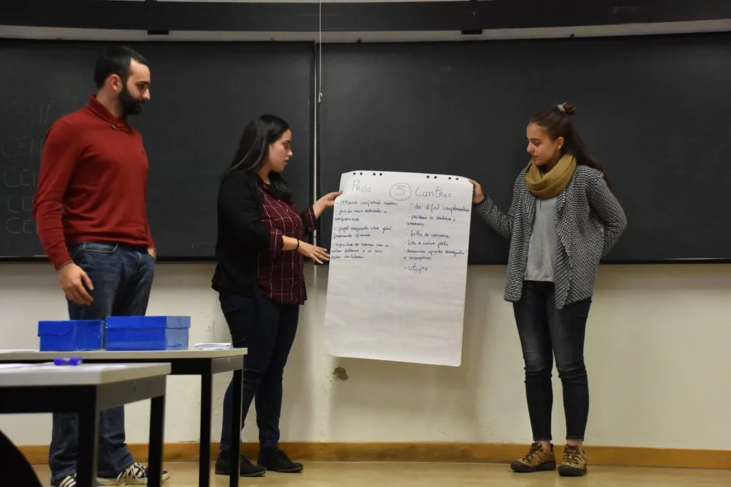 Three students presenting their handwritten poster.
