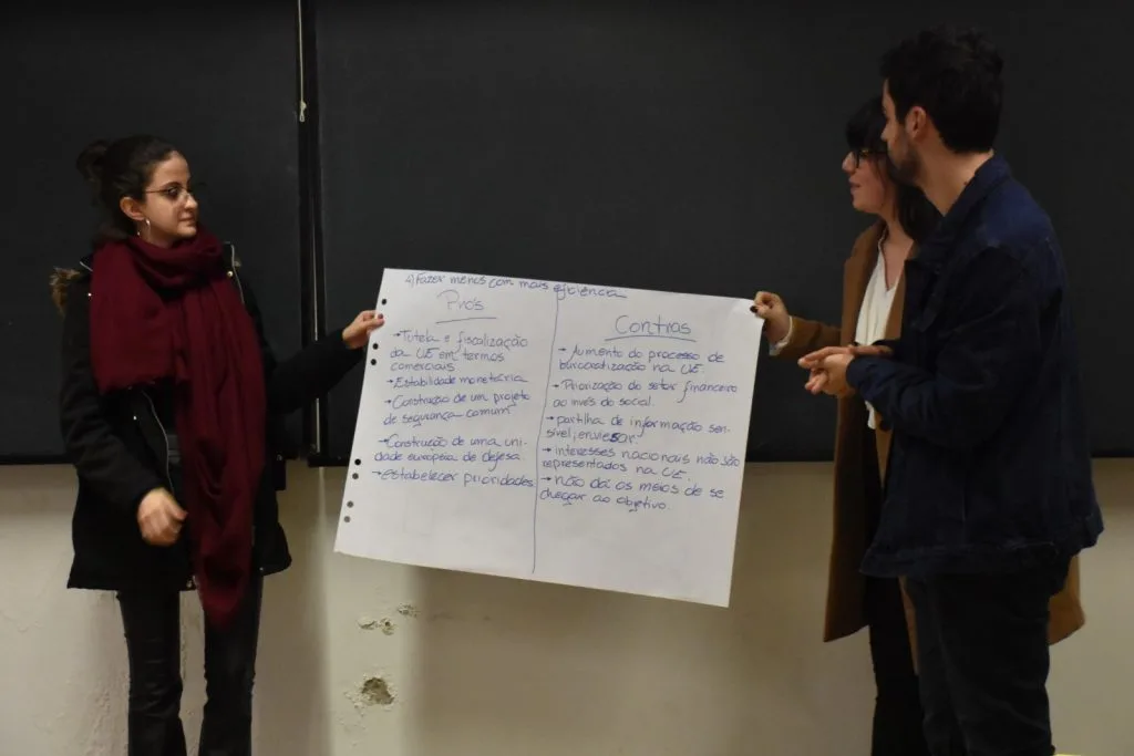 Three students presenting their handwritten poster.