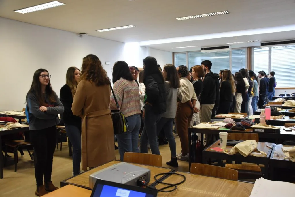 Participants forming two standing rows, facing one another, talking.