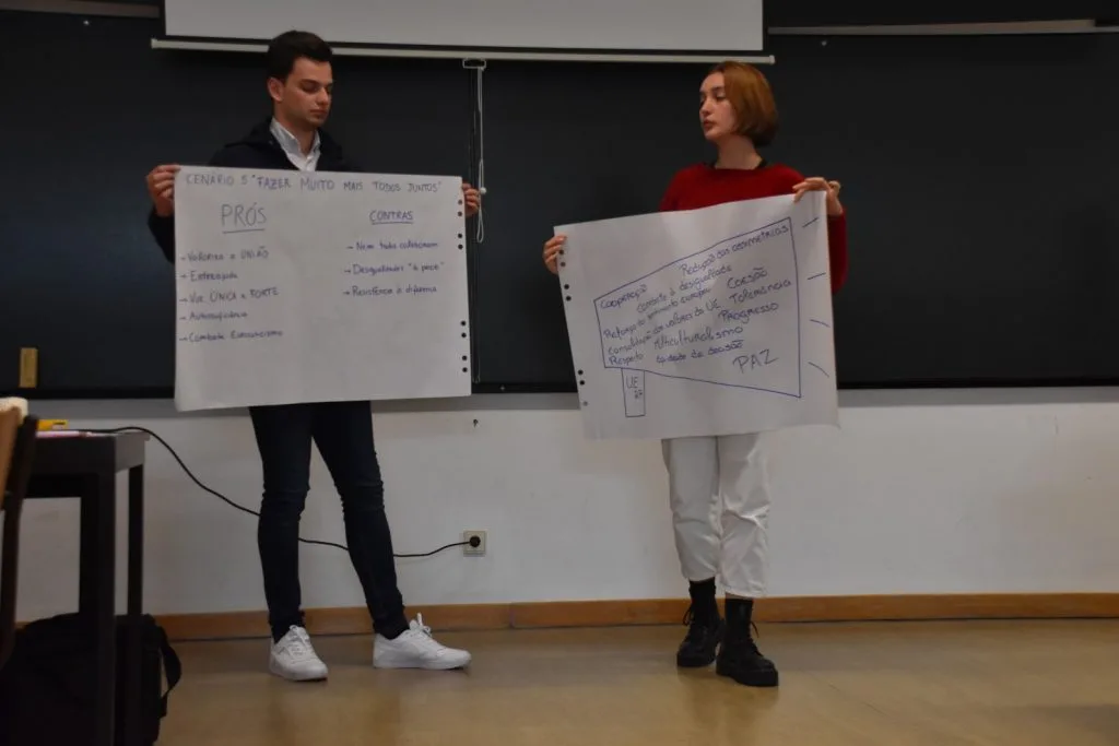 Two students presenting their handwritten posters.