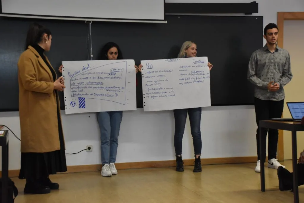 Four students presenting their handwritten posters.