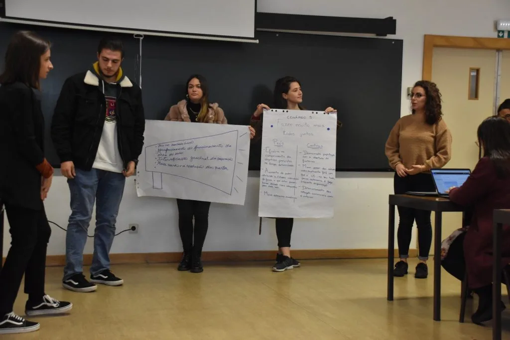 Five students presenting their handwritten posters.