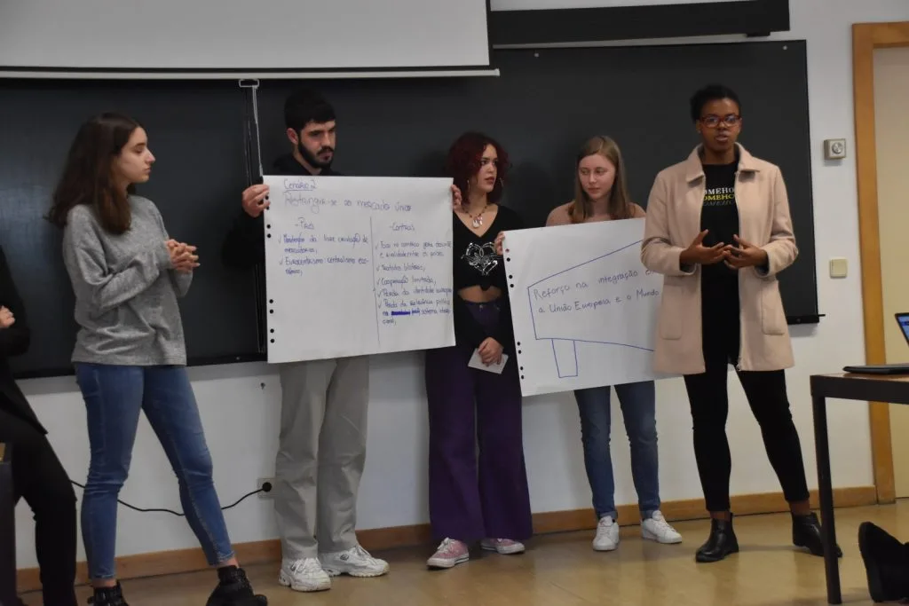 Five students presenting their handwritten posters
