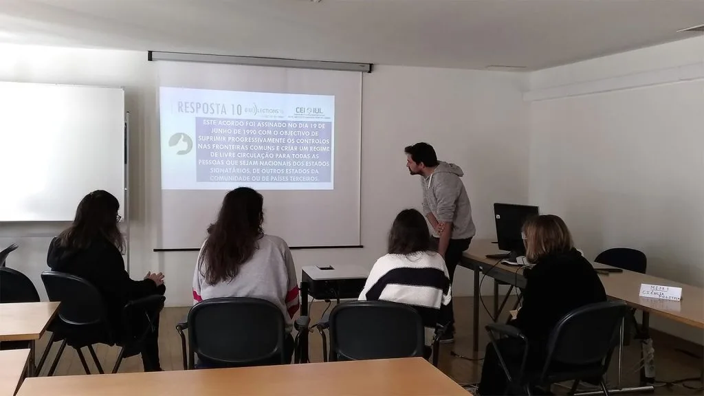 Four students listening to a presentation by a representative of CEI-IUL.