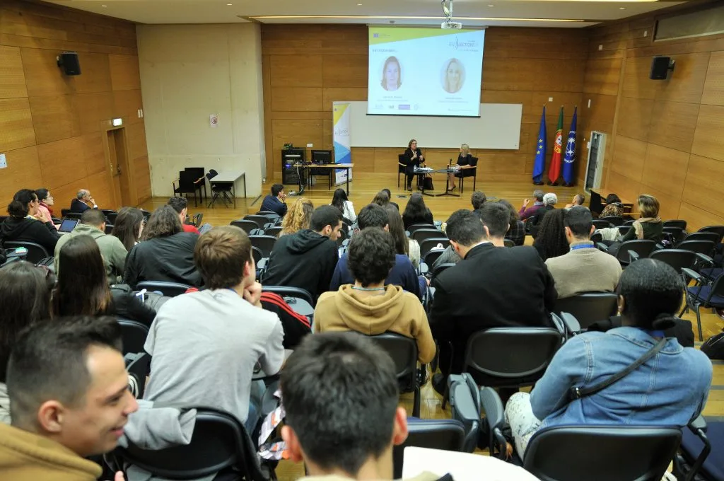 A perspective of the audience and the ongoing talk from the back of the auditorium.