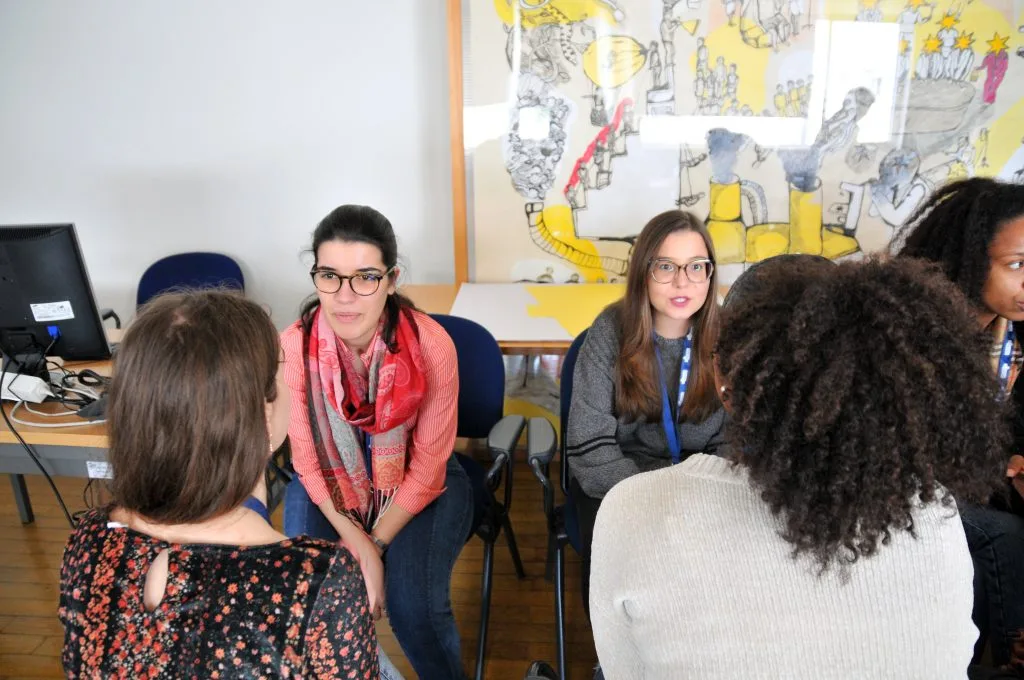 Students seated in two rows, each talking with the one seated in front of them during the“May the vote be with EU: workshop on future scenarios” training session.