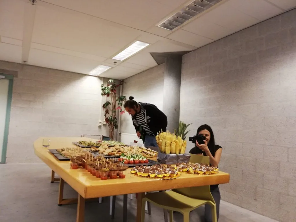 Buffet table and two participants next to it.