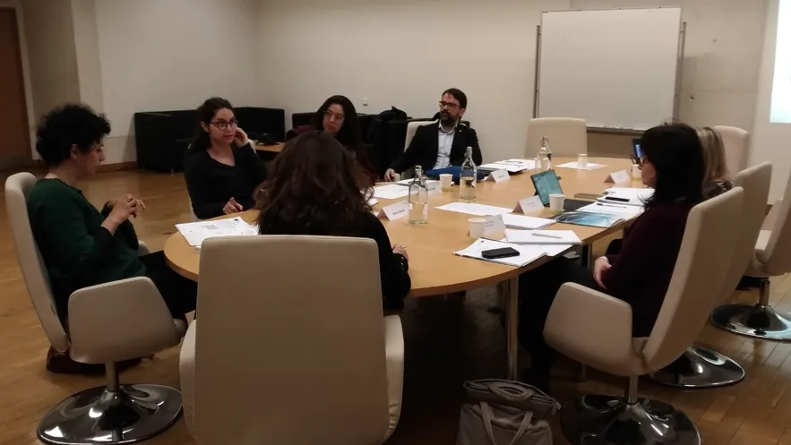 Representatives seated around a table talking.