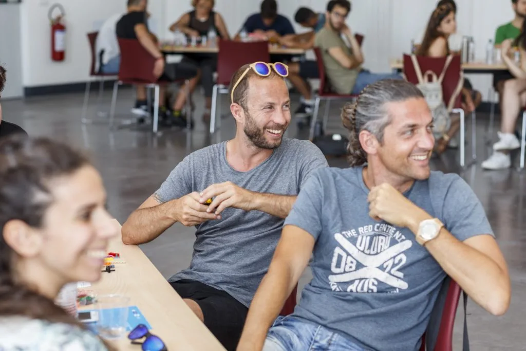 Three smiling participants, seated around a table.