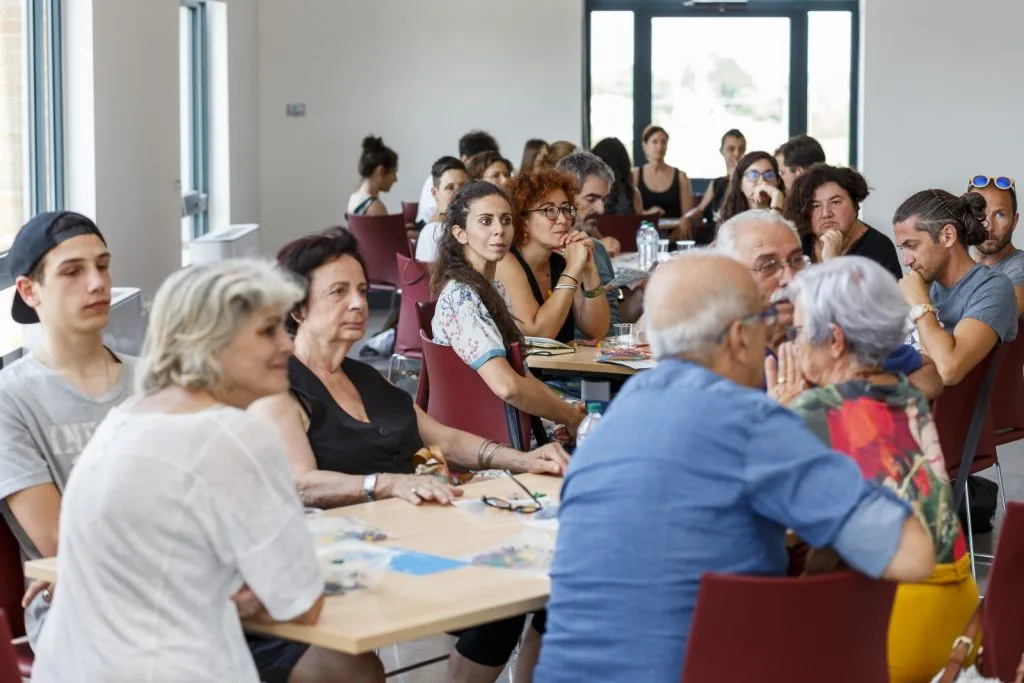 Participants seated around multiple tables.
