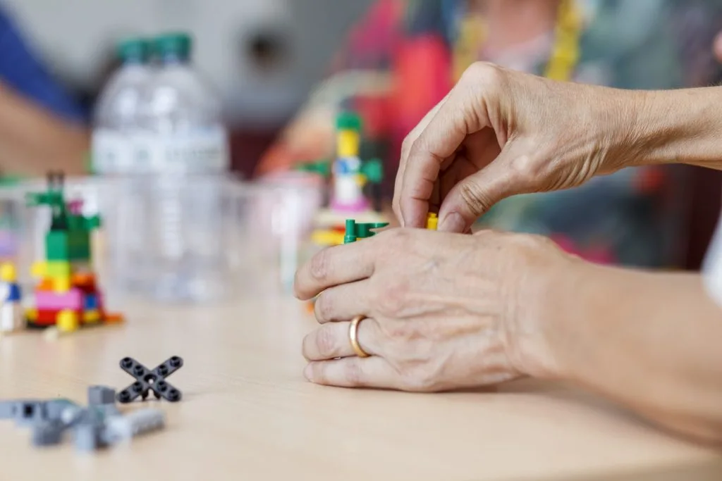 Participant's hands engaged in constructing with Lego.