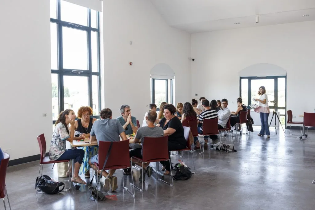 Participants seated around multiple tables.