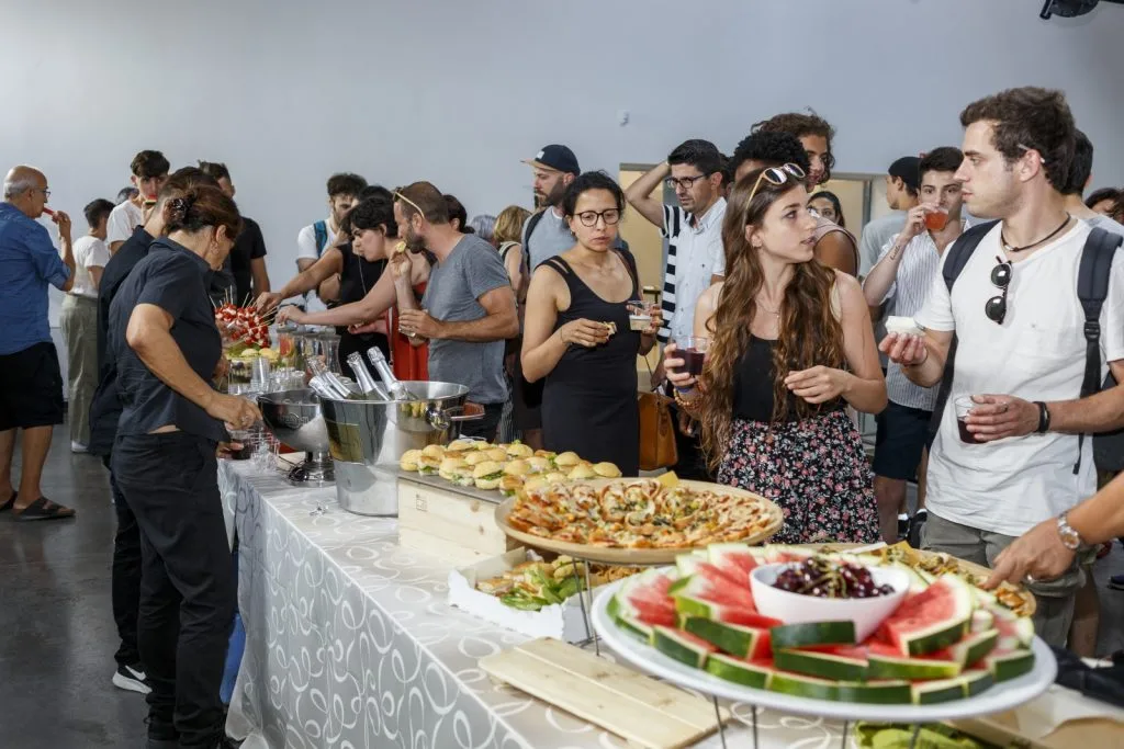 Buffet table with participants chatting around and using it.