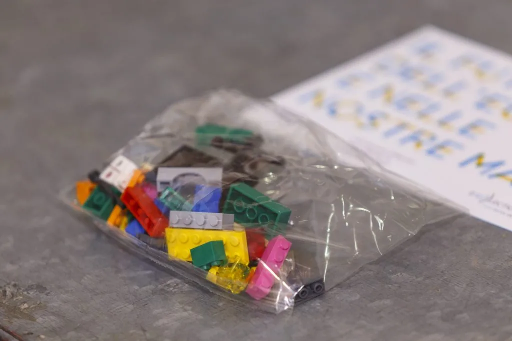 An unopened bag of Lego pieces on a table.