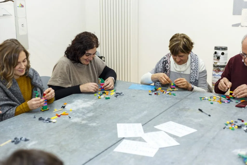 Four participant adults building with their Lego pieces.