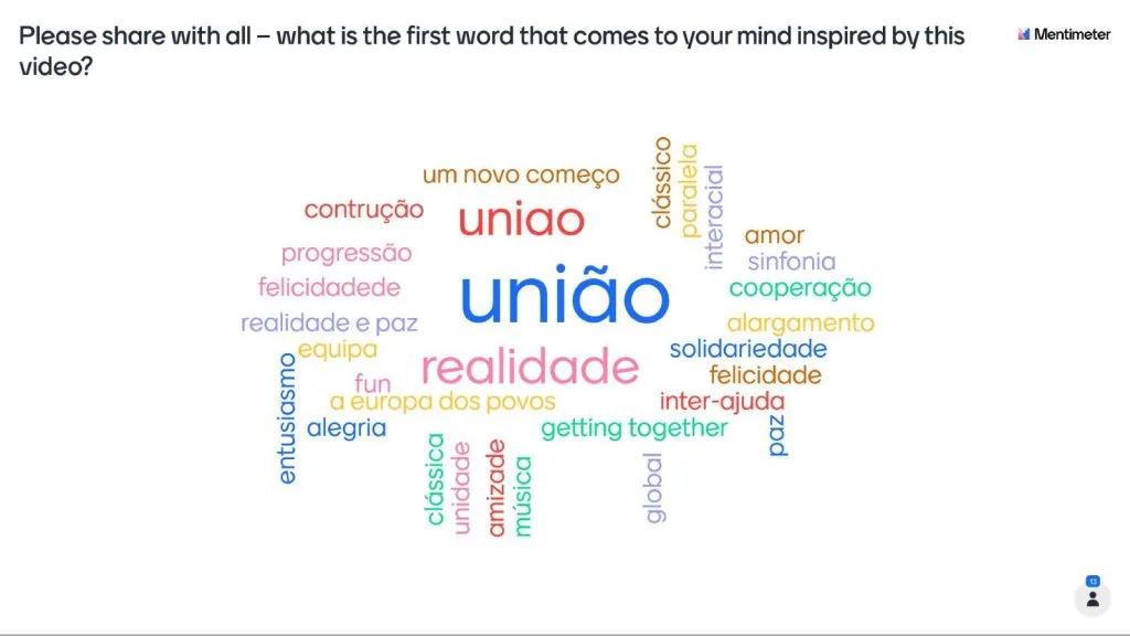 Videoconference still showing a multi-colored word cloud, with words like "union" and "reality" in portuguese standing out.