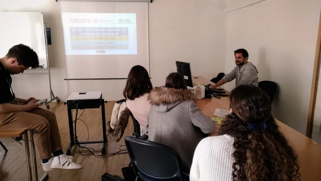 Four students listening to a presentation by a representative of CEI-IUL.
