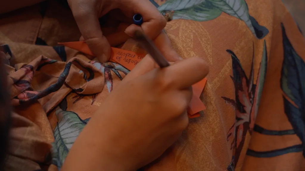 Participant writing on a paper airplane.