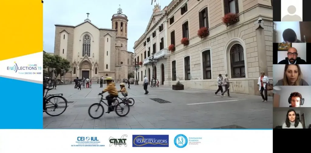 Videoconference still showing partners' logos on the bottom and an european city street with people walking and riding bicycles, and a church at the end of it.