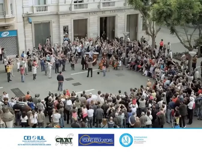 Videoconference still with the partners' logos on the bottom and an image of a group of people on a street forming a circle around performers.